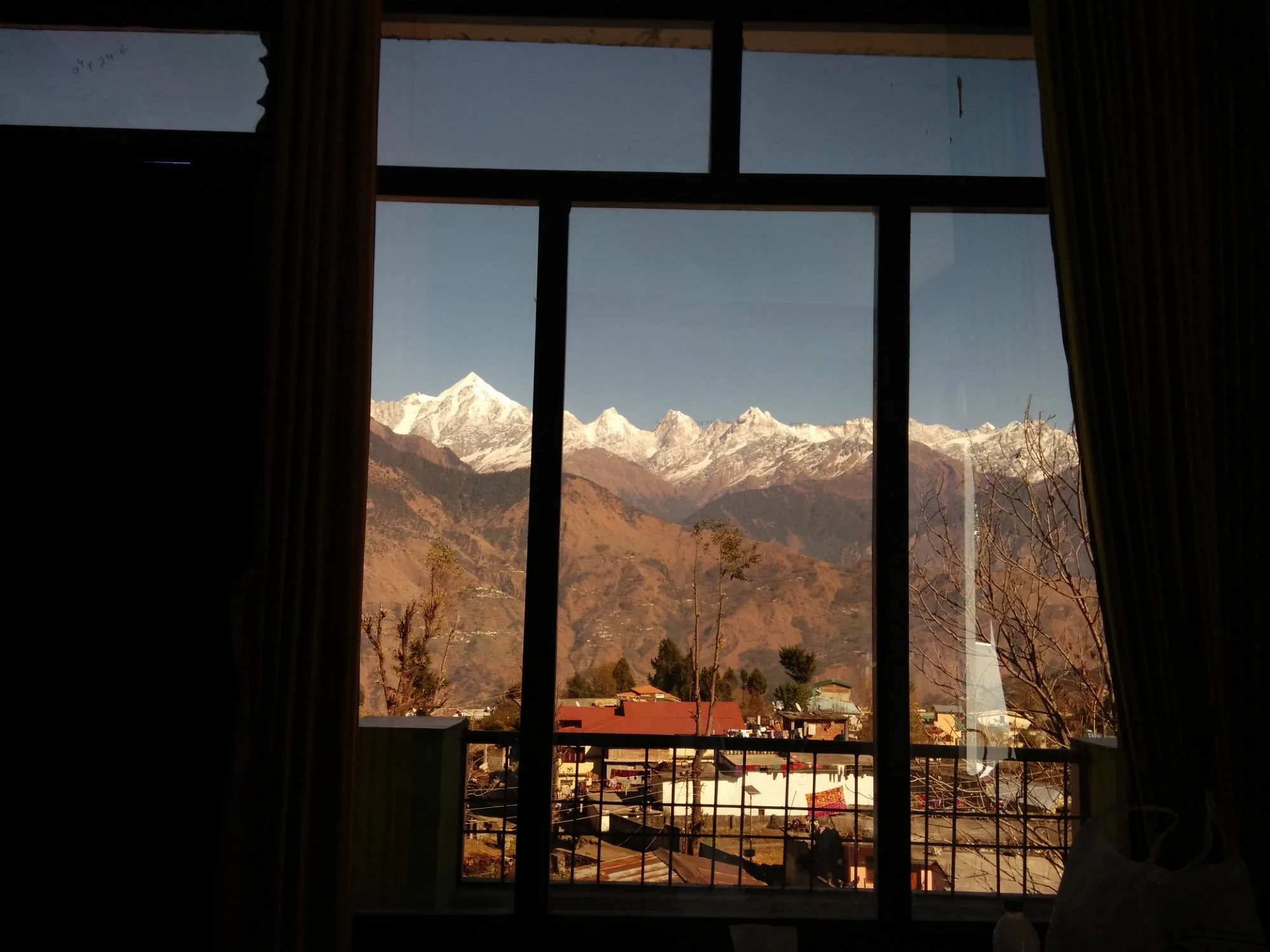 Snow-capped Panchachuli peaks framed by a room window on a clear winter day — TripAdvisor guest photo